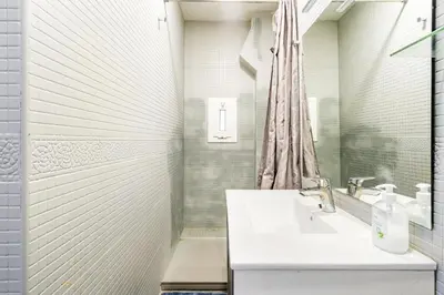 a white bathroom with a sink and a shower at Beachside Bliss Charming 1-bedroom, Barceloneta in Barcelona