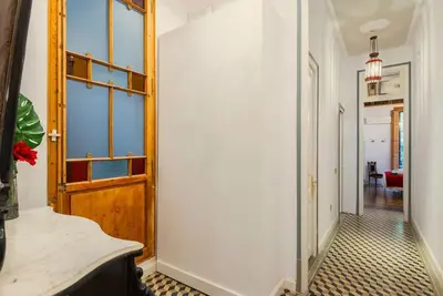 a hallway with a wooden door and a room with a table at Large patio 4 bedrooms 4 bathrooms of which 3 en-suite in Barcelona
