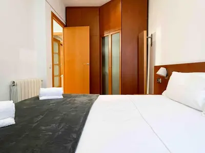 a bed with two pillows on it in a room at Hostourist@Bcn Apartamento Monumental in Barcelona