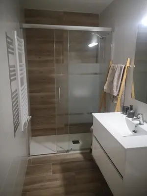 a bathroom with a glass shower and a sink at Apartament LA SAL in Pineda de Mar