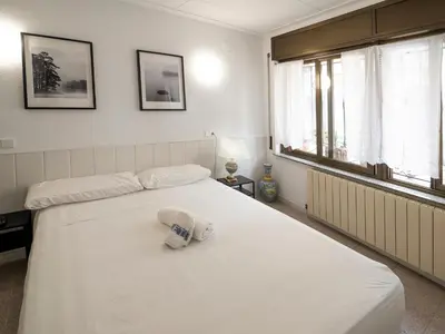 a bedroom with a white bed with towels on it at L'Hostalet GuestHouse in Pineda de Mar