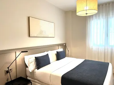 a bedroom with a large bed with blue and white pillows at Sitges Spaces Garden Oasis 3 Bedroom 2 Bath Garden in Sitges
