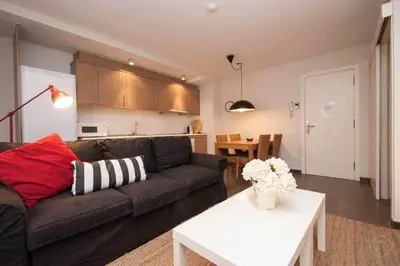 a living room with a couch and a table at Port VII Apt centrico acogedor w balcon 23 in Barcelona