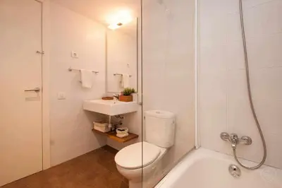a white bathroom with a toilet and a sink at Port VII Apt centrico acogedor w balcon 23 in Barcelona