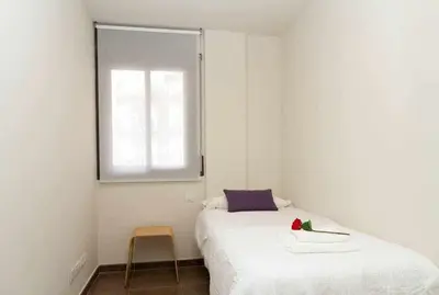 a small bedroom with a bed and a window at Port III Apart céntrico ideal familias 11 in Barcelona