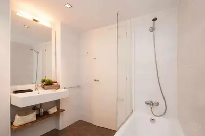 a white bathroom with a sink and a shower at Port IV Apart céntrico ideal grupos 12 in Barcelona
