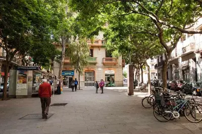 a street with people walking down a street with trees at Port VI Apart céntrico ideal familias 22 in Barcelona