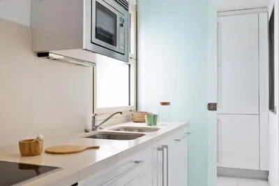 a white kitchen with a sink and a microwave at Ola Living Plaza Catalunya in Barcelona