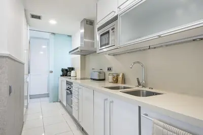 a kitchen with white cabinets and a sink at Ola Living Plaza Catalunya in Barcelona