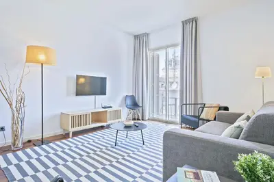 a living room with a couch and a tv at Ola Living Plaza Catalunya in Barcelona