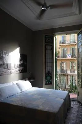 a bedroom with a bed and a window with a building at Casa del Mediterraneo in Barcelona