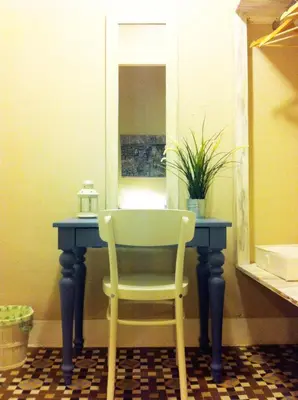 a chair sitting at a blue table with a mirror at Casa del Mediterraneo in Barcelona