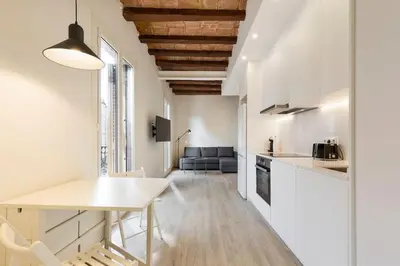 a kitchen and living room with white walls and a table at Modern and bright apartment well located in Gracia in Barcelona