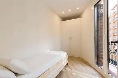 a bedroom with a bed and a large window at Modern and bright apartment well located in Gracia in Barcelona