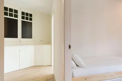 a white room with a bed and a window at Modern and bright apartment well located in Gracia in Barcelona