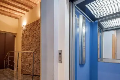 a hallway with a blue door and a stone wall at GuestReady - Bright home near Montjuïc in Barcelona