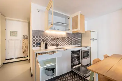 a kitchen with white cabinets and a wooden table at CATERINA Sagrera in Barcelona