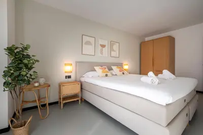 a white bedroom with two beds and a plant at CATERINA Sagrera in Barcelona