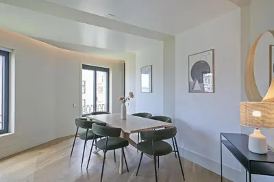 a dining room with a table and green chairs at Ola Living Paseo de Gracia in Barcelona