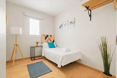 a white bedroom with a bed and a window at Tendency Apartments Sagrada Familia Penthouse in Barcelona