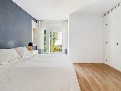 a white bedroom with a large bed and a window at Villa Alella Panoramic Views in Alella