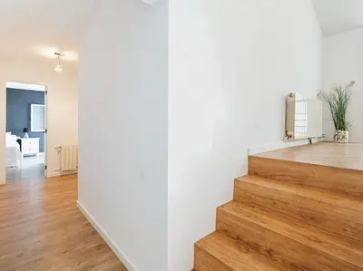 a room with white walls and a staircase with wood floors at Villa Alella Panoramic Views in Alella