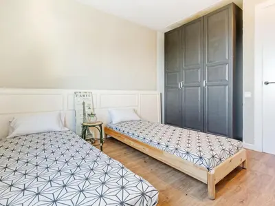 a bedroom with two beds and a cabinet at Villa Alella Panoramic Views in Alella
