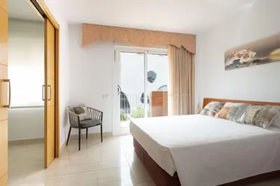 a bedroom with a bed and a window and a chair at Apartamento Luxury Gran Via 2 in Hospitalet de Llobregat