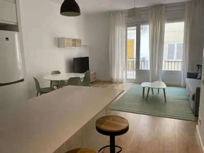 a kitchen and living room with a table and chairs at Gaudi Street Apartments in Sitges
