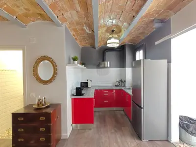 a kitchen with red cabinets and a refrigerator at Magnificent apartment Camp Nou in Hospitalet de Llobregat
