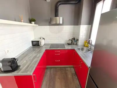 a kitchen with red cabinets and a sink at Magnificent apartment Camp Nou in Hospitalet de Llobregat
