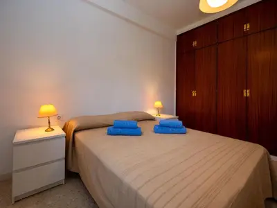 a bedroom with a bed with blue pillows on it at Apartment Els Pins by Interhome in Sant Vicenç de Montalt