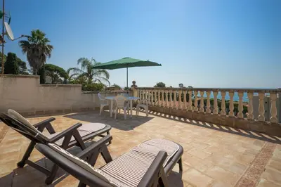 a patio with chairs and a table and an umbrella at Basketball court, pool, BBQ, gardens, seaviews in San Pol de Mar