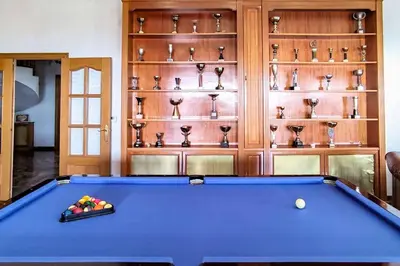 a large blue pool table in a room with shelves at Basketball court, pool, BBQ, gardens, seaviews in San Pol de Mar