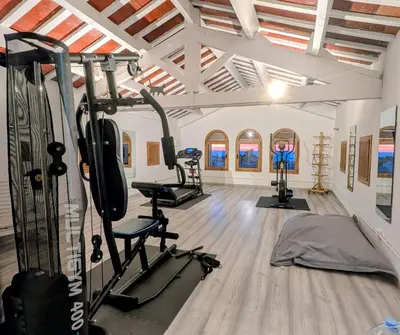 a gym with treadmills and exercise equipment in a room at Historic house 5 minutes walk from the beach in San Pol de Mar