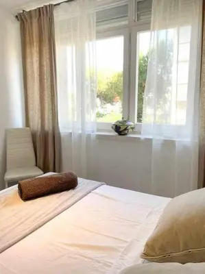 a bedroom with a bed with a window and a chair at Apartment Coloma Piscina y Parking Hostem in Vilanova i la Geltrú