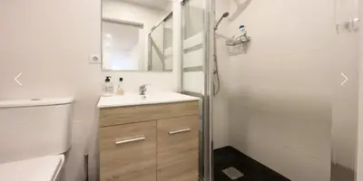 a kitchen with white cabinets and a white refrigerator at Precioso Estudio en Sant Gervasio in Barcelona