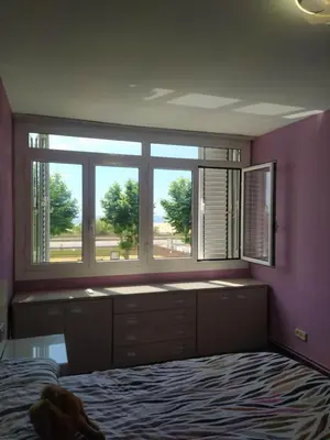 a bedroom with purple walls and a large window at Primera línea de mar y piscina a 20 minutos de Barcelona in Premiá de Mar