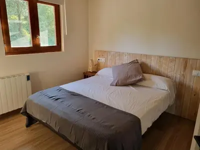 a bedroom with a bed with a wooden headboard and a window at Cal Masses , St. Salvador de Guardiola in Guardiola