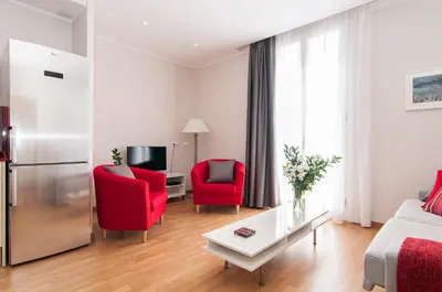 a living room with two red chairs and a couch at Pelayo Deluxe Apartments in Barcelona