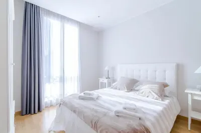 a white bedroom with a large bed with two white towels on it at Pelayo Deluxe Apartments in Barcelona