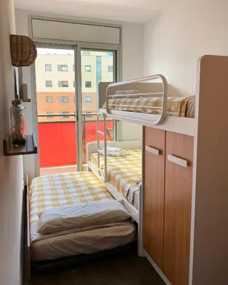 a small room with a bunk bed and a window at Barcelona Beach Breeze in Barcelona