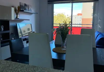 a dining room with a table and chairs and a television at Barcelona Beach Breeze in Barcelona