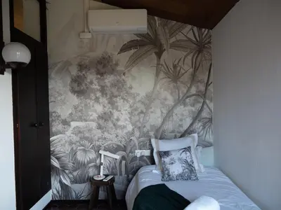 a bedroom with a wall mural of plants at Les Alzines - Chalet con gran piscina cerca de Barcelona in Orrius
