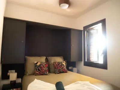a bedroom with a bed with a black headboard and a window at Les Alzines - Chalet con gran piscina cerca de Barcelona in Orrius