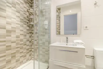 a white bathroom with a sink and a shower at Canela Homes BARCELONA BALMES in Barcelona