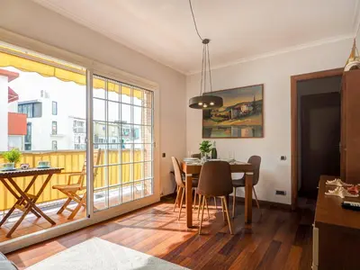 a dining room with a table and a balcony at The Beach Apartment by Hello Homes Sitges in Sitges