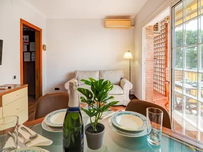 a dining room with a table with a bottle of wine at The Beach Apartment by Hello Homes Sitges in Sitges