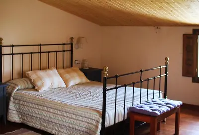 a bedroom with a bed and a wooden ceiling at El Celler de la Guàrdia in Montserrat