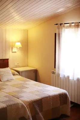 a bedroom with a large bed and a window at El Celler de la Guàrdia in Montserrat